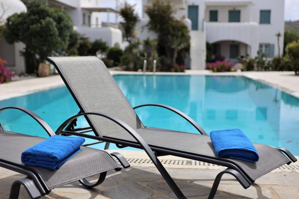 a reclining chair with blue cushions next to a swimming pool at Kalypso Pool Villa at Ornos in Ornos