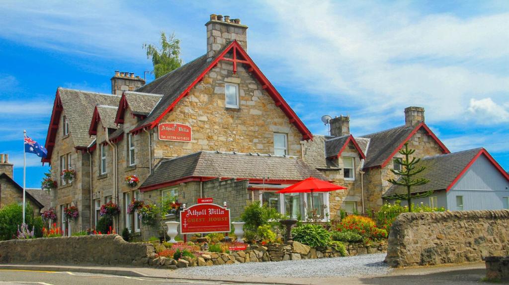 ein großes Steingebäude mit einem Schild davor in der Unterkunft Atholl Villa Guest House in Pitlochry