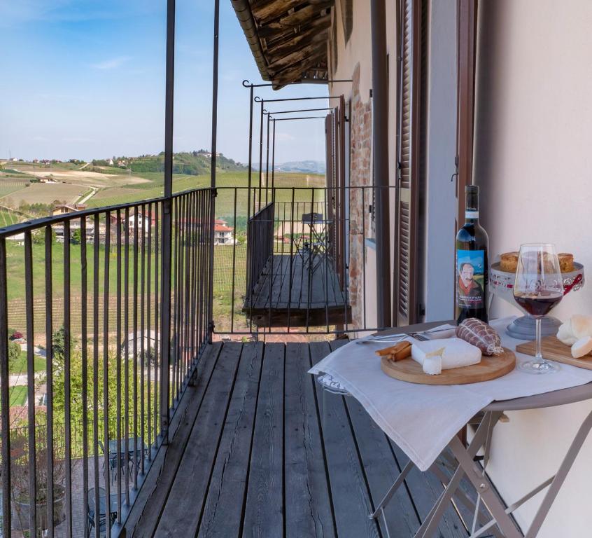 un tavolo con un bicchiere di vino sul balcone di Il Borgo B&B a Castellinaldo