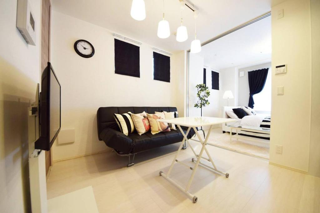 uma sala de estar com um sofá preto e uma mesa em Three Tokyo 101 em Tóquio