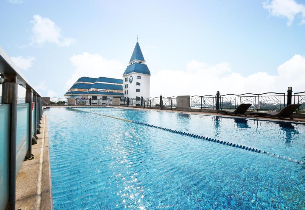 a large swimming pool with a building in the background at Fullon Hotel Tamsui Fishermen&#39;s Wharf in Tamsui