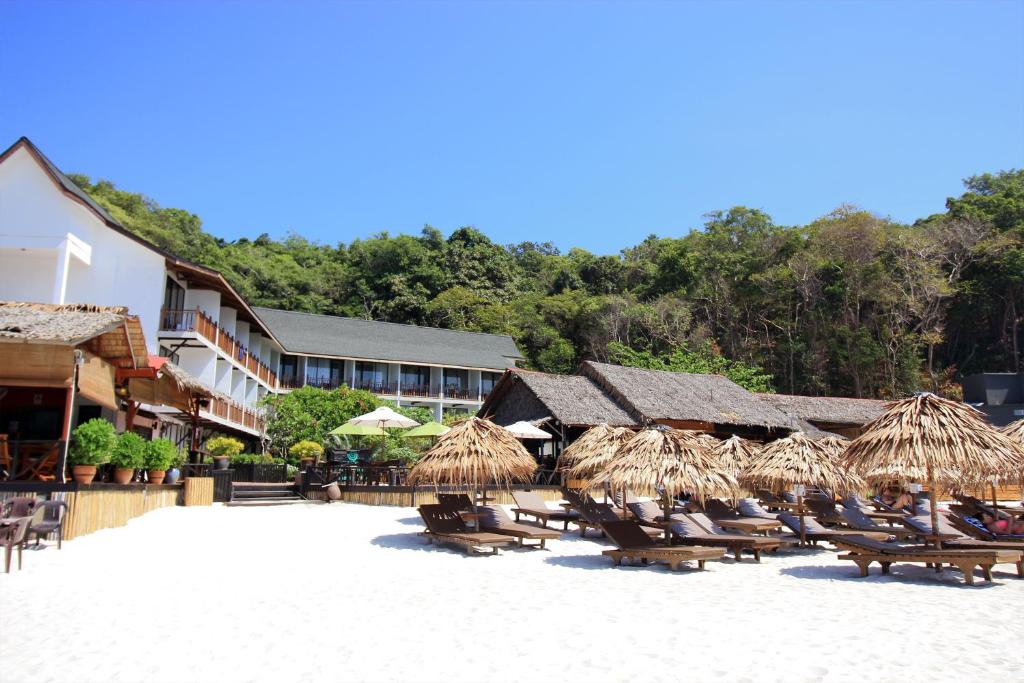 a patio area with chairs, tables and umbrellas at Bubu Resort in Perhentian Islands