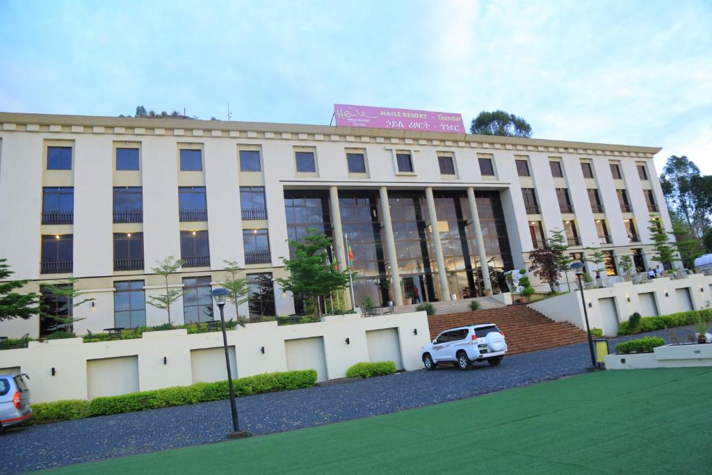 un edificio con una macchina bianca parcheggiata di fronte di Haile Resort-Gondar a Gonder