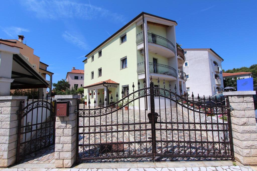 una casa blanca detrás de una valla negra en Apartments Villa Mara, en Rovinj