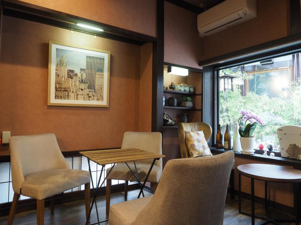 a restaurant with chairs and a table and a window at Ikariya Ryokan in Yamanouchi