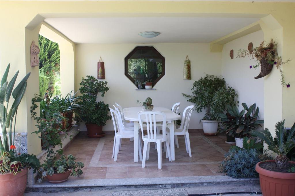a white table and chairs in a room with plants at Villa Orlando in Bova Marina