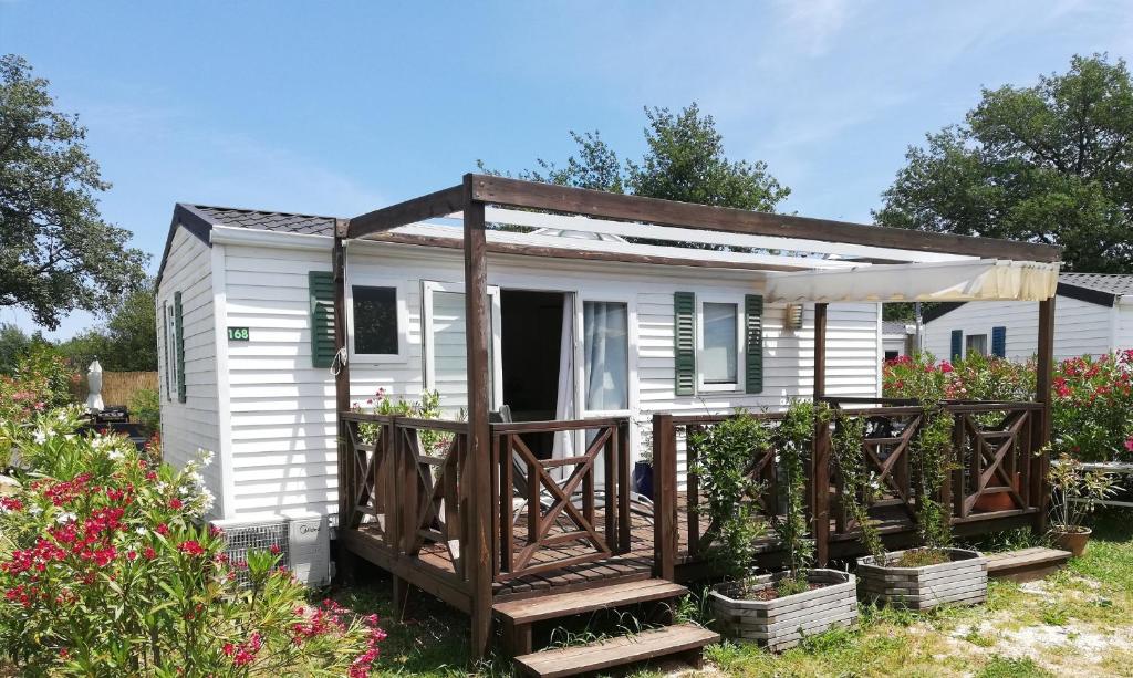 a small white tiny house with a porch at Mobile-Home in Argelès-sur-Mer