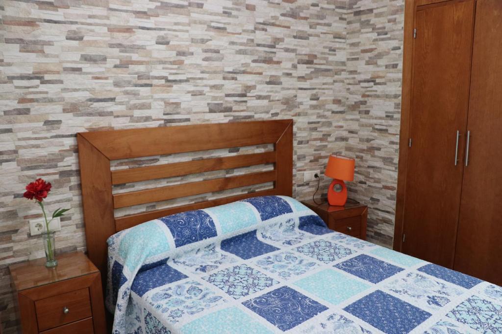 sypialnia z łóżkiem i ceglaną ścianą w obiekcie Apartamento para 3 en el centro w mieście Conil de la Frontera