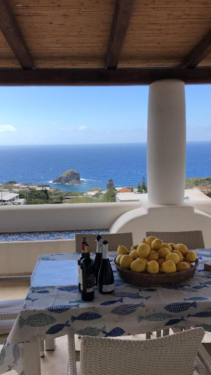 una mesa con un plato de comida con vistas al océano en La Casuzza Dei Re, en Malfa