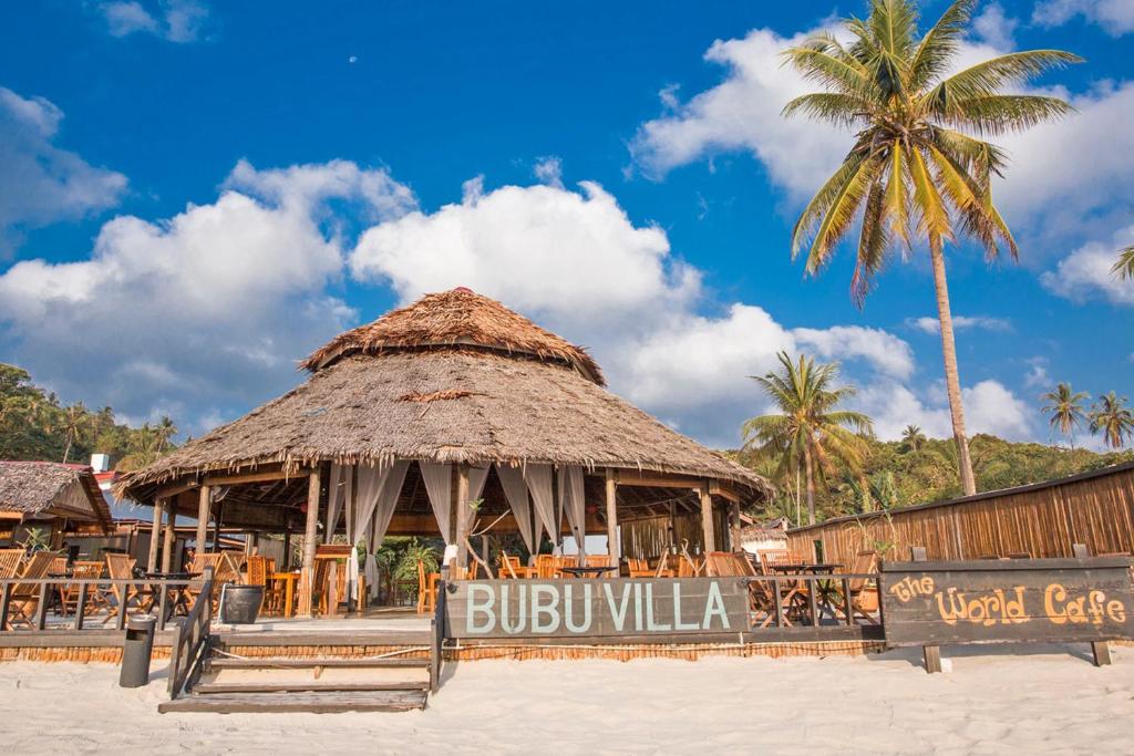 una cabaña en la playa con una palmera en BuBu Villa, en Islas Perhentian