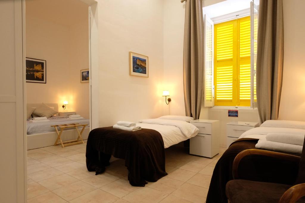 a bedroom with two beds and a mirror at The Maltese Sun in Sliema