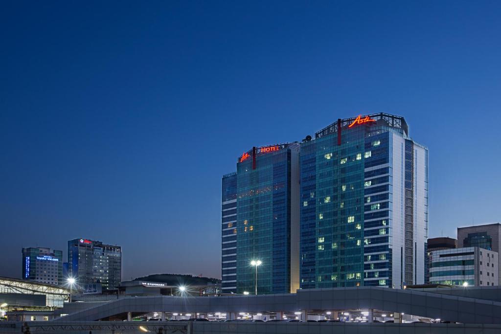 a tall building with lights on top of it in a city at ASTI Hotel Busan Station in Busan