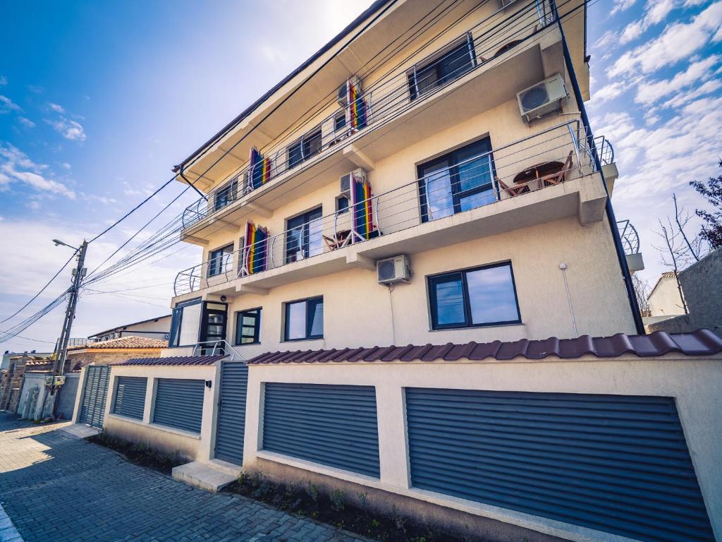 a building with two garage doors and a balcony at Casa in Culori Vama Veche in Vama Veche