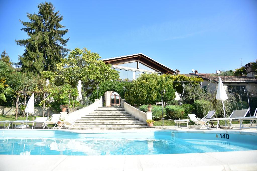 a house with a swimming pool with chairs and stairs at Ca' San Sebastiano Wine Resort & Spa in Camino