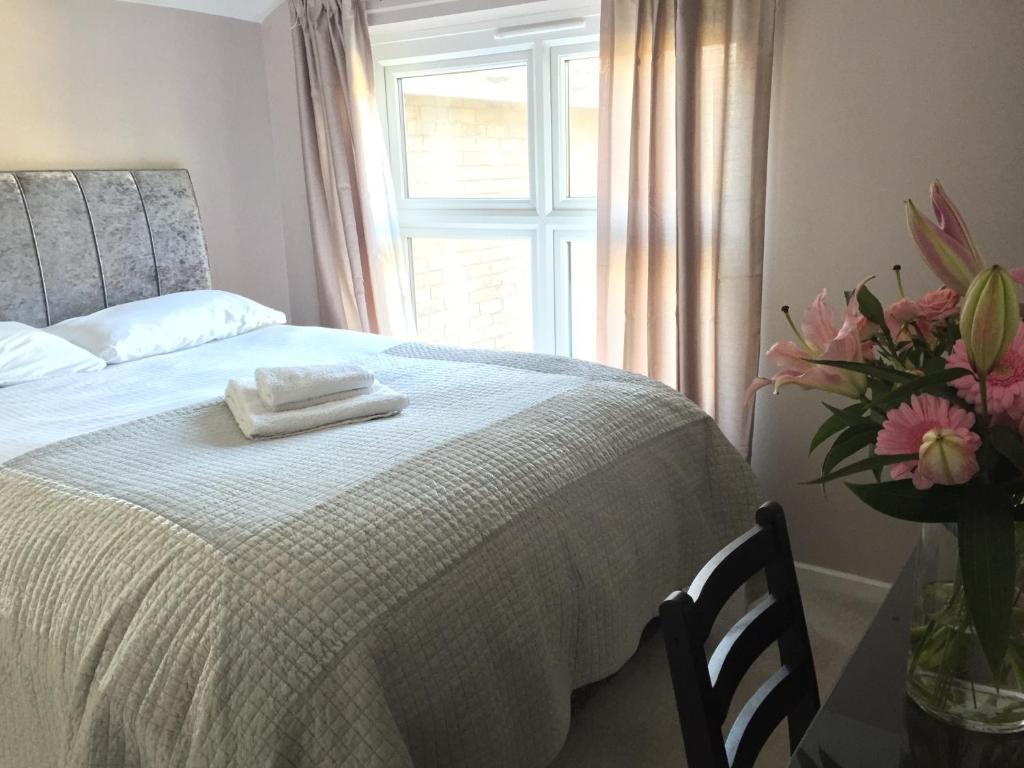 a bedroom with a bed with a white blanket and a window at Shepherds Rest in Kegworth