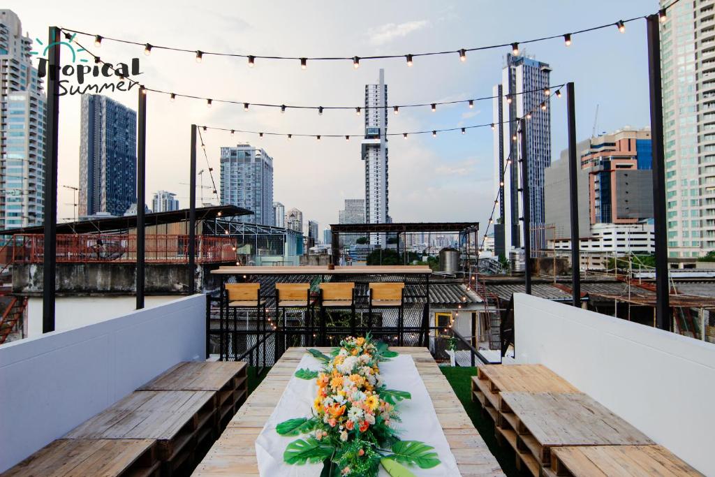 a table on a rooftop with a view of the city at Tropical Summer Hostel in Bangkok