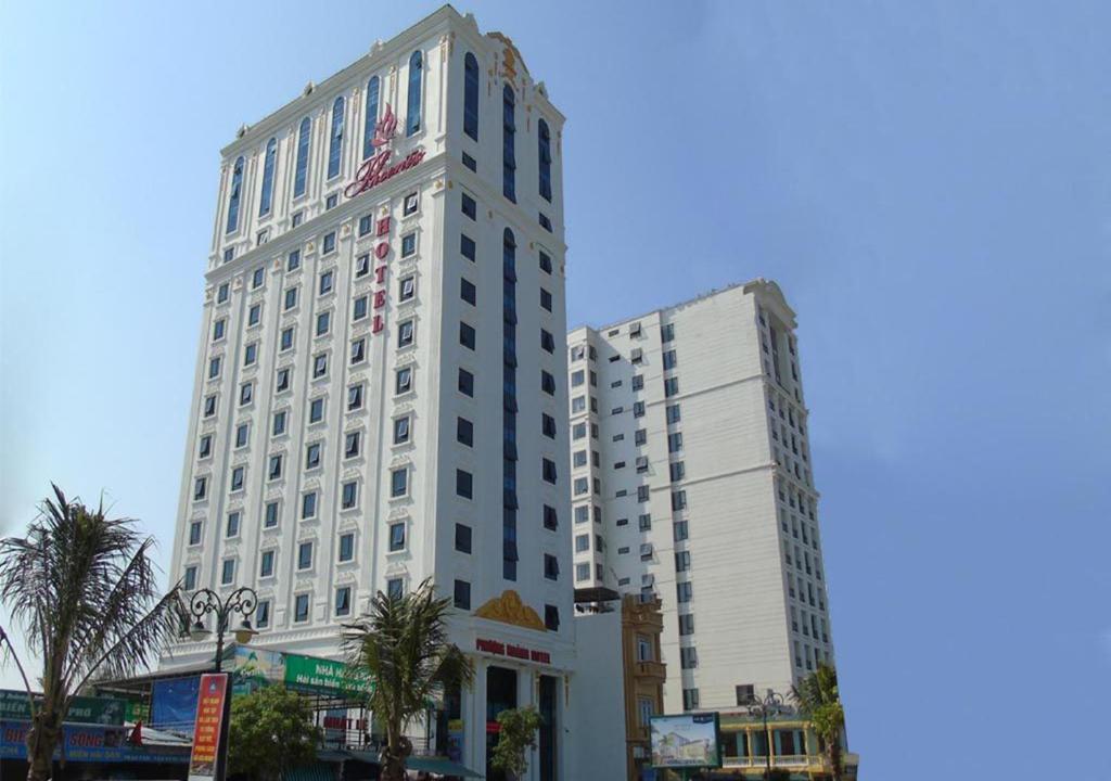 a tall white building next to two other buildings at Phuong Hoang Hotel 2 in Sầm Sơn