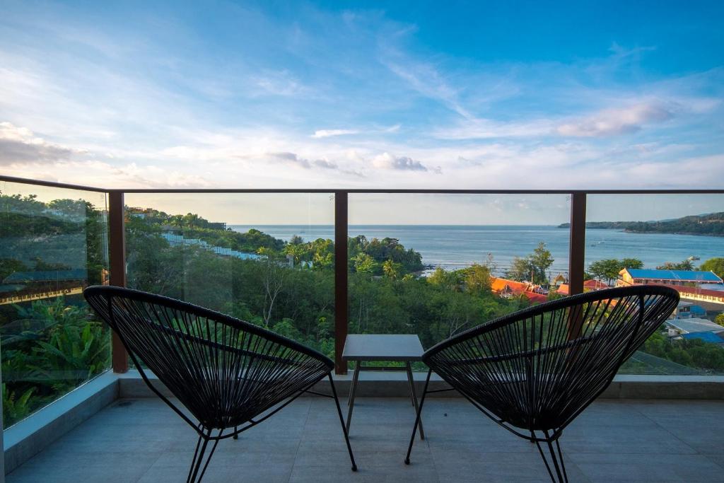 two chairs on a balcony with a view of the water at Oceana Sea View Apartments - Kamala Beach in Kamala Beach