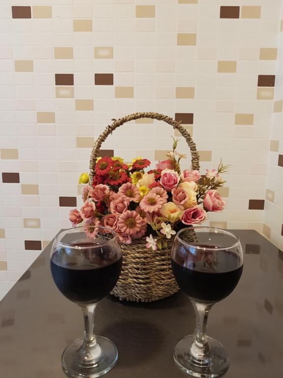 a basket of flowers and two glasses of wine at Apartment in Tbilisi in Tbilisi City