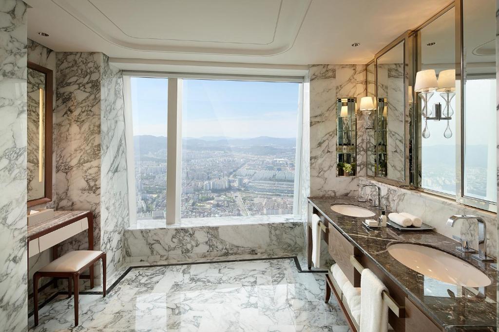 a bathroom with two sinks and a large window at Signiel Seoul in Seoul