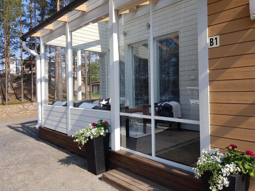 eine abgeschirmte Veranda eines Hauses mit Blumen in der Unterkunft Rantahiekka B1 in Kalajoki