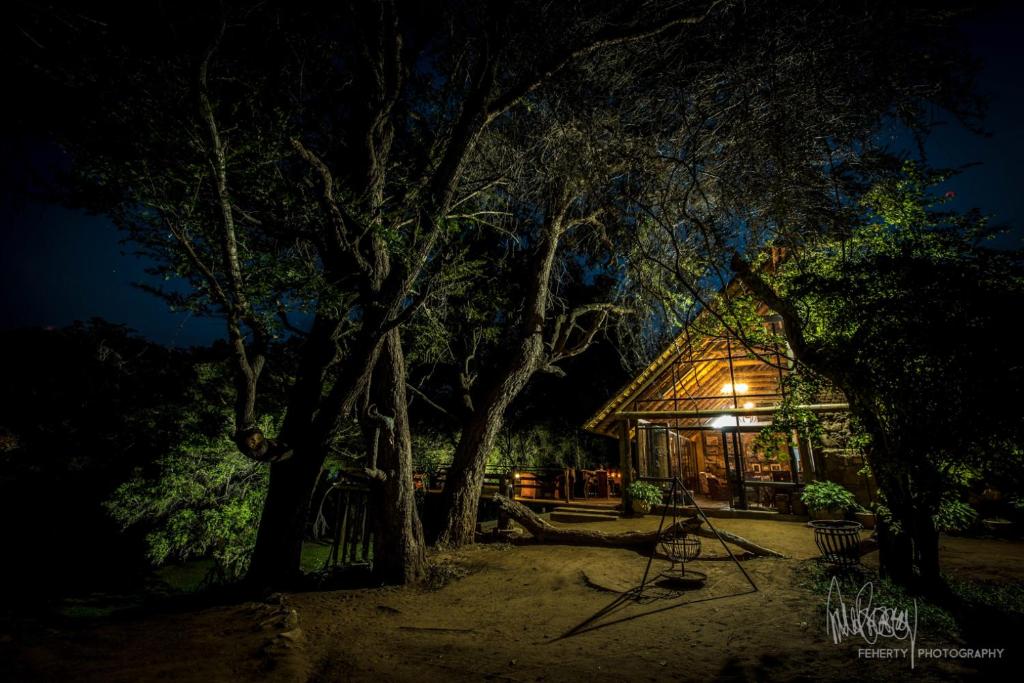 een hut in het bos 's nachts bij Rio Dos Elefantes River Camp in Hoedspruit