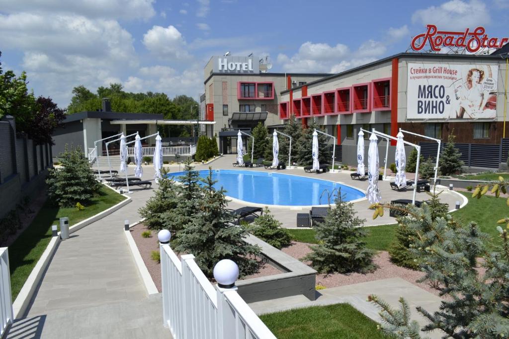 a hotel with a swimming pool in front of a building at Road Star Hotel in Dnipro