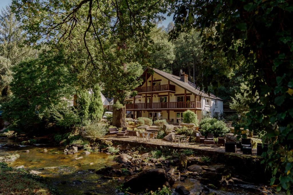 een huis met een vijver ervoor bij Logis Auberge de Pont Calleck in Inguiniel