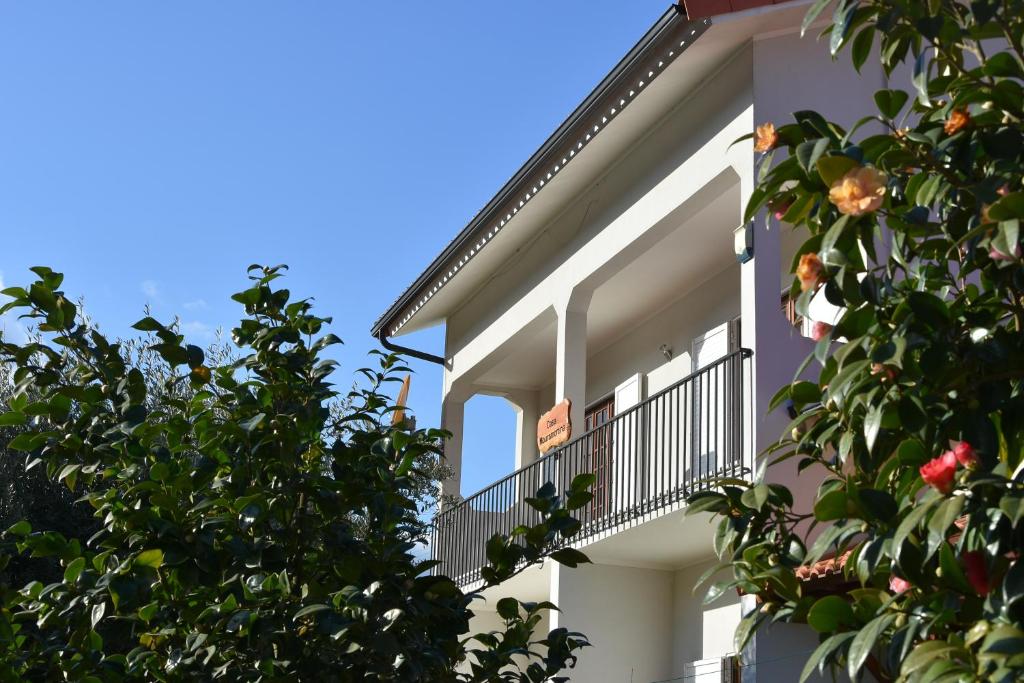een wit gebouw met een balkon en bomen bij Casa Mouramortina in Vila Nova de Poiares
