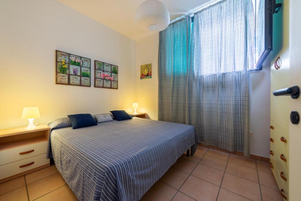 トッレ・デル・オルソにあるAppartamento Parco dei Piniのベッドルーム1室(ベッド1台、大きな窓付)