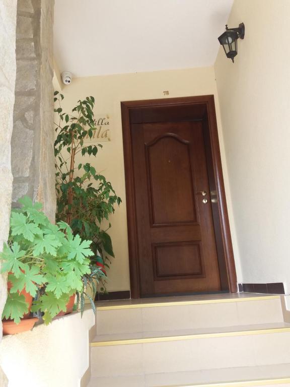 a wooden door in a building with potted plants at ВИЛА СВИЛА in Sozopol