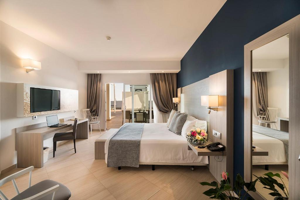 a hotel room with a large bed and a desk at Royal Palm Resort & Spa - Adults Only in Playa Jandia