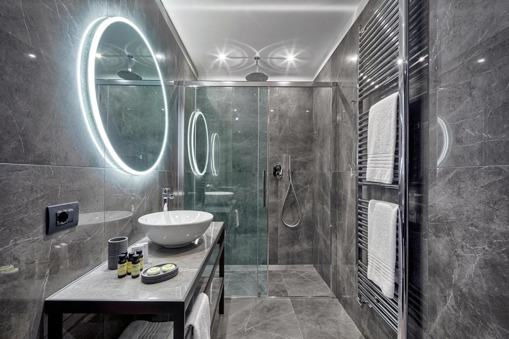 a bathroom with a sink and a glass shower at Hotel American-Dinesen in Venice