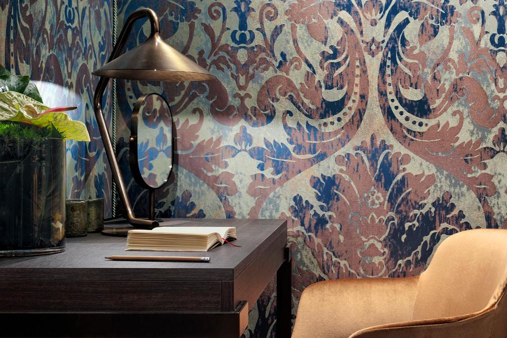 a desk with a lamp and books on a wall at Hotel American-Dinesen in Venice