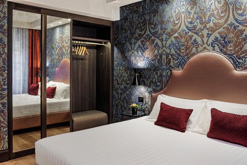 a bedroom with a large white bed with red pillows at Hotel American-Dinesen in Venice