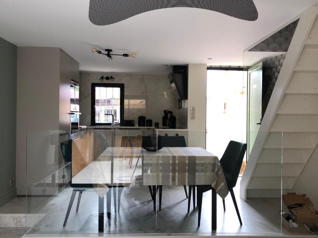 une salle à manger avec une table et des chaises et un escalier dans l'établissement Les Oceanes, à Gruissan