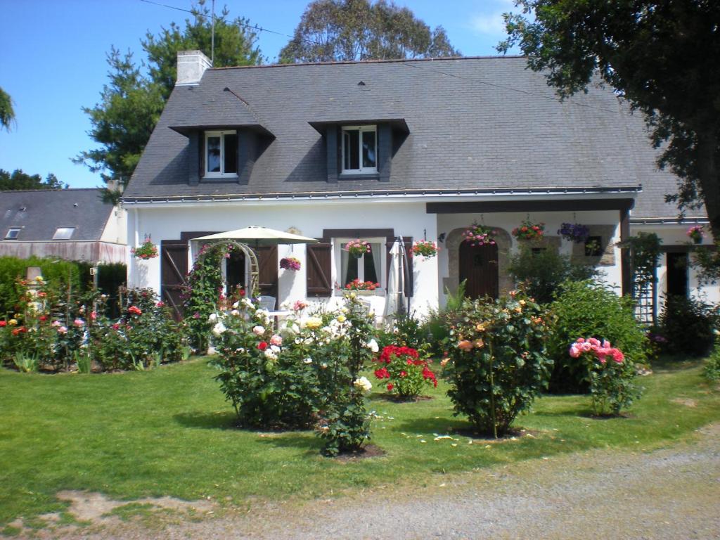 een wit huis met bloemen in de tuin bij Chez Annick in Guérande