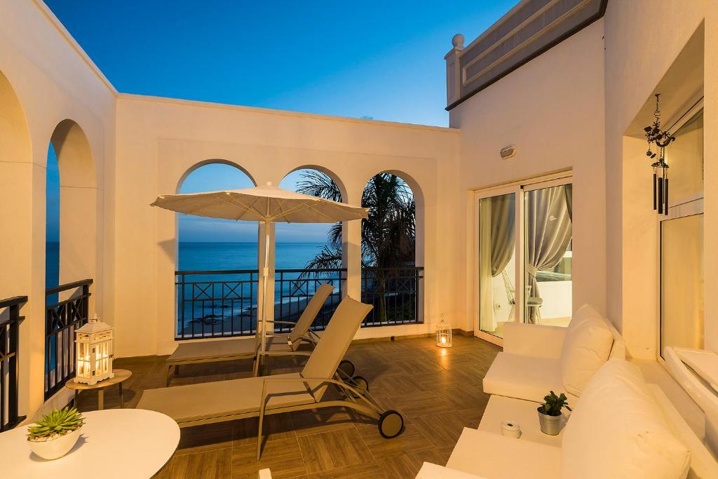 a living room with a chair and an umbrella at Royal Palm Resort & Spa - Adults Only in Playa Jandia