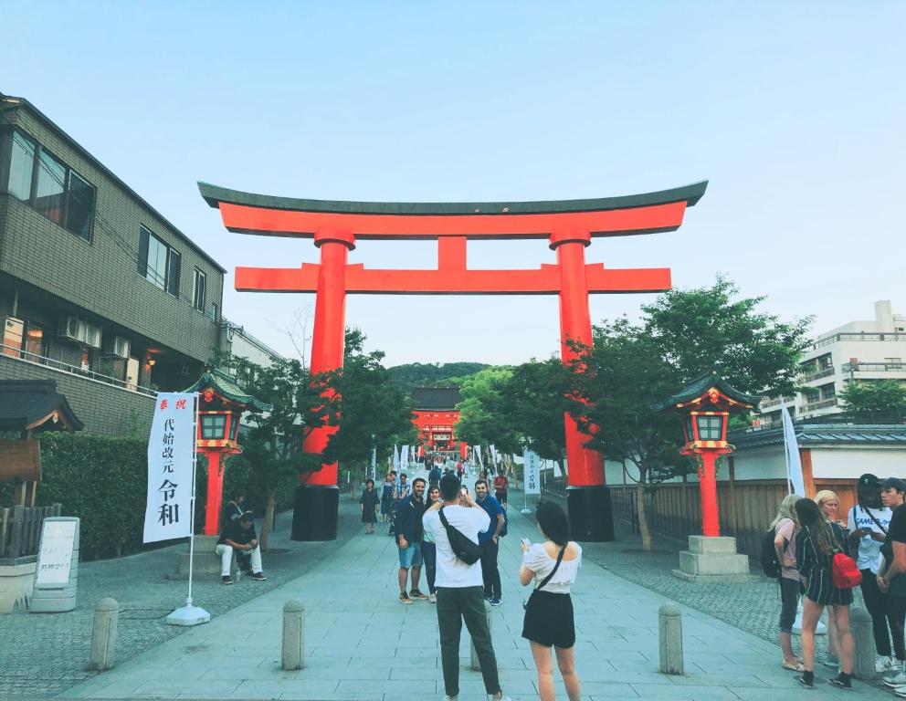 a torii gate in a city with a crowd of people at Kyoto Inari Guest House Tonoya villa in Kyoto