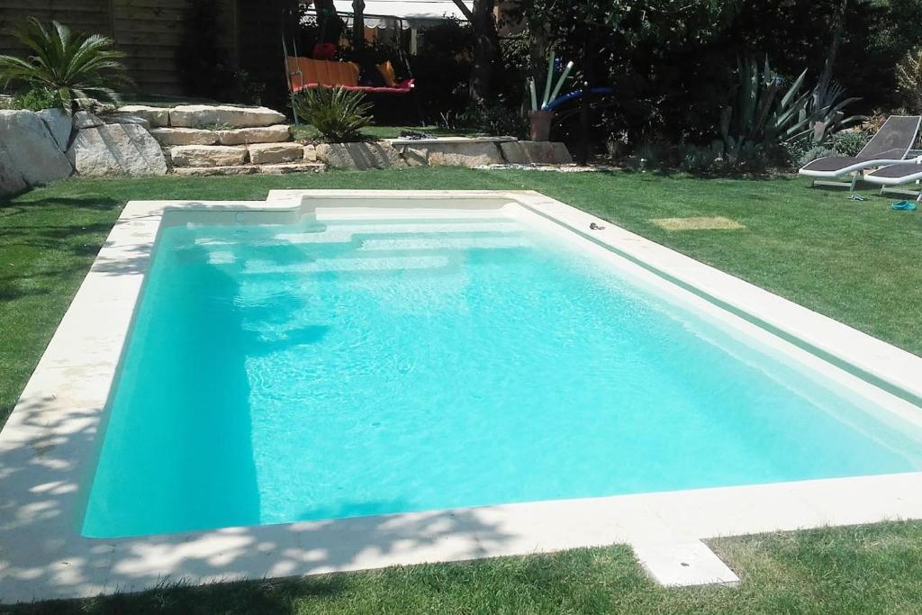 une grande piscine bleue dans une cour dans l'établissement Villa LES FIGUIERS, à Cavalaire-sur-Mer