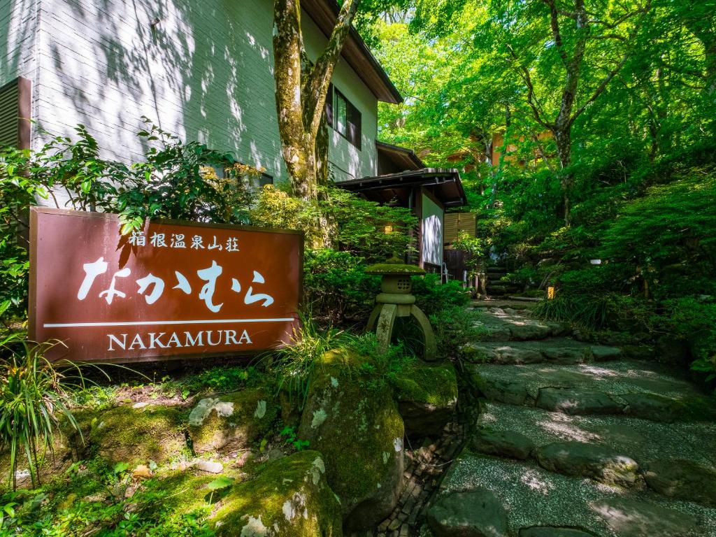 un panneau en face d'un bâtiment dans un jardin dans l'établissement Hakone Onsen Sanso Nakamura, à Hakone