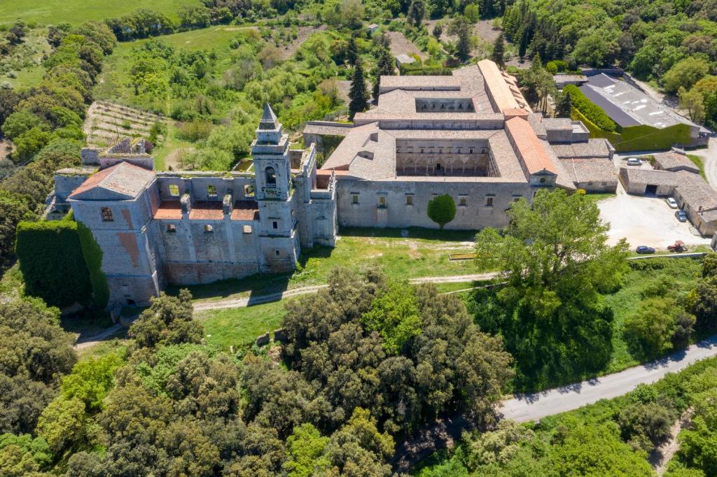 Abbazia Santa Maria del Bosco في Contessa Entellina: اطلالة جوية على قلعة قديمة فيها اشجار