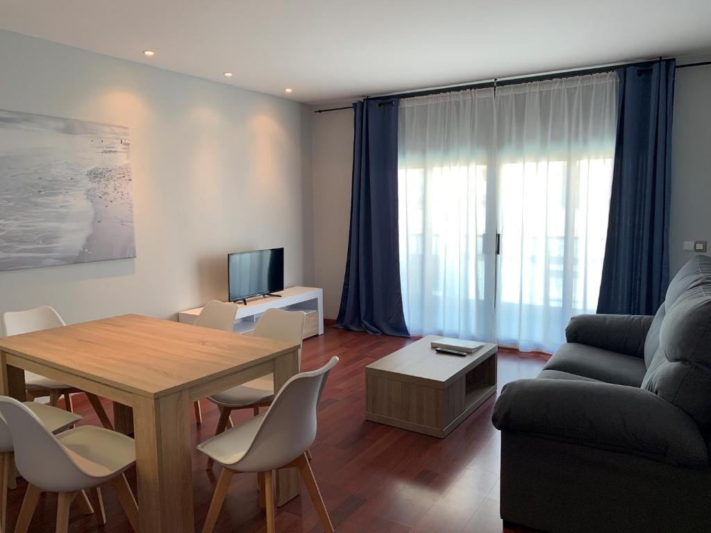 a living room with a table and a couch at Palamós Apartamentos in Palamós