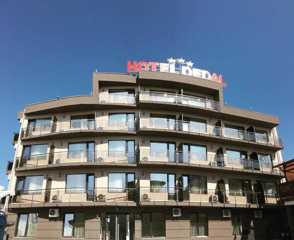 a hotel with a sign on top of it at Hotel Dedal in Mamaia Nord