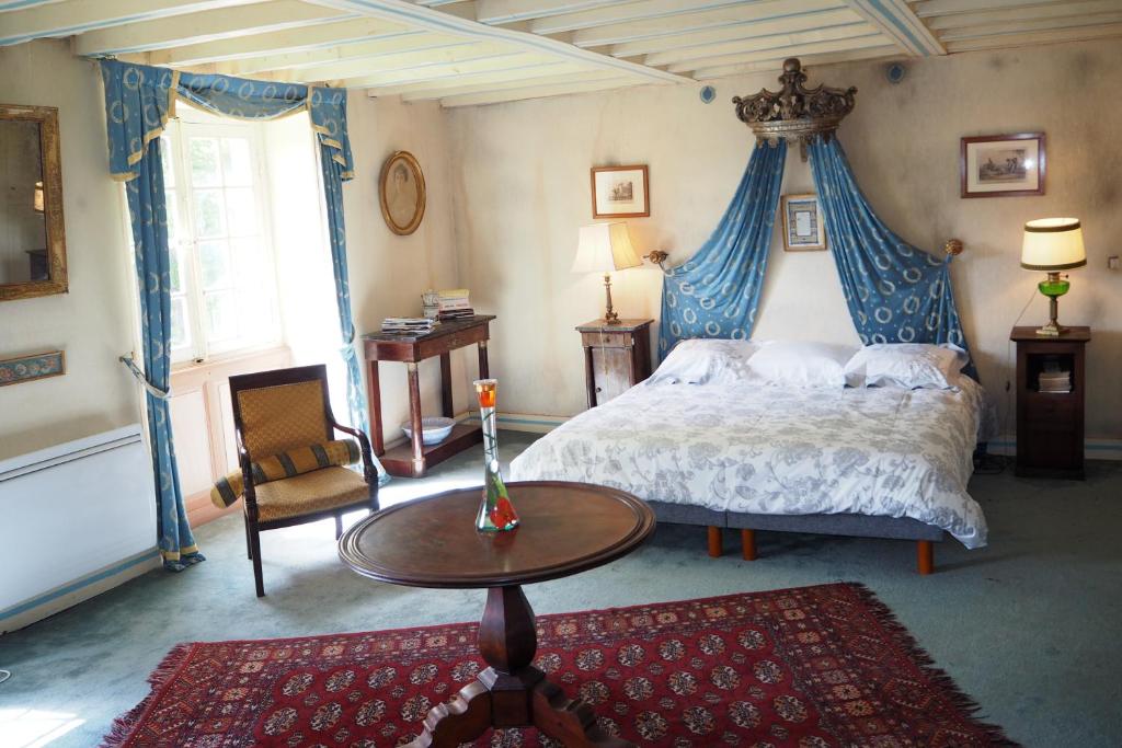 Un dormitorio con una cama y una mesa. en Gentilhommière de Lurcy le Bourg, en Lurcy-le-Bourg
