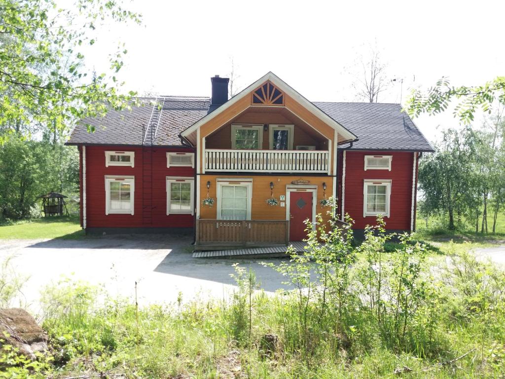 a red house with a porch and a balcony at Maatilamatkailu Heikin Tupa in Ylipää