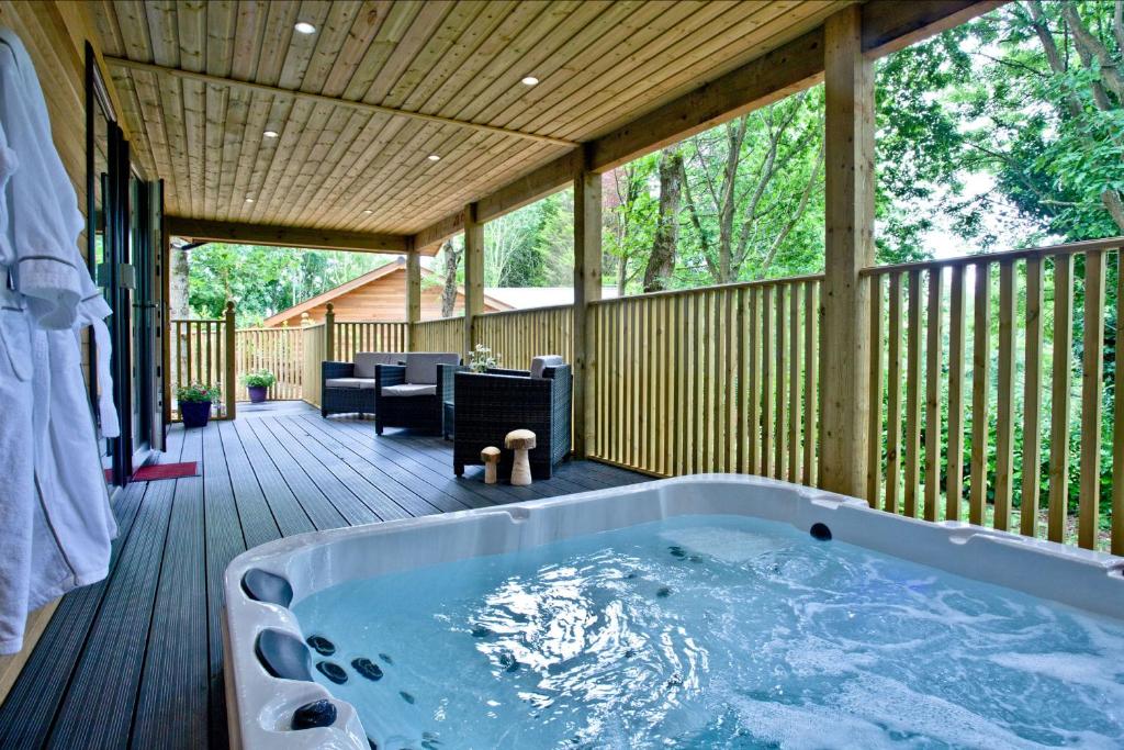 a hot tub on the deck of a house at Cedar Lodge, South View Lodges, Exeter in Exeter