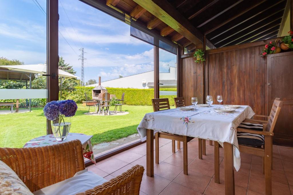 a dining room with a table and chairs on a patio at Apartamentos Rurales Villa de Sain Cudillero in Cudillero