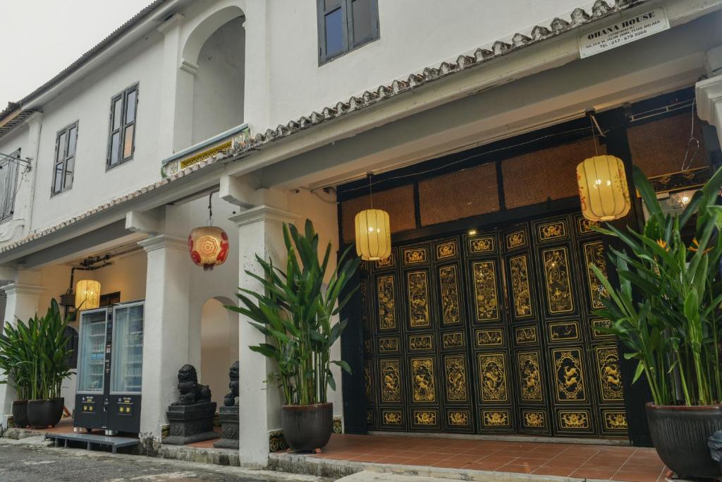 een winkel met een grote houten deur bij Ohana House HQ in Melaka