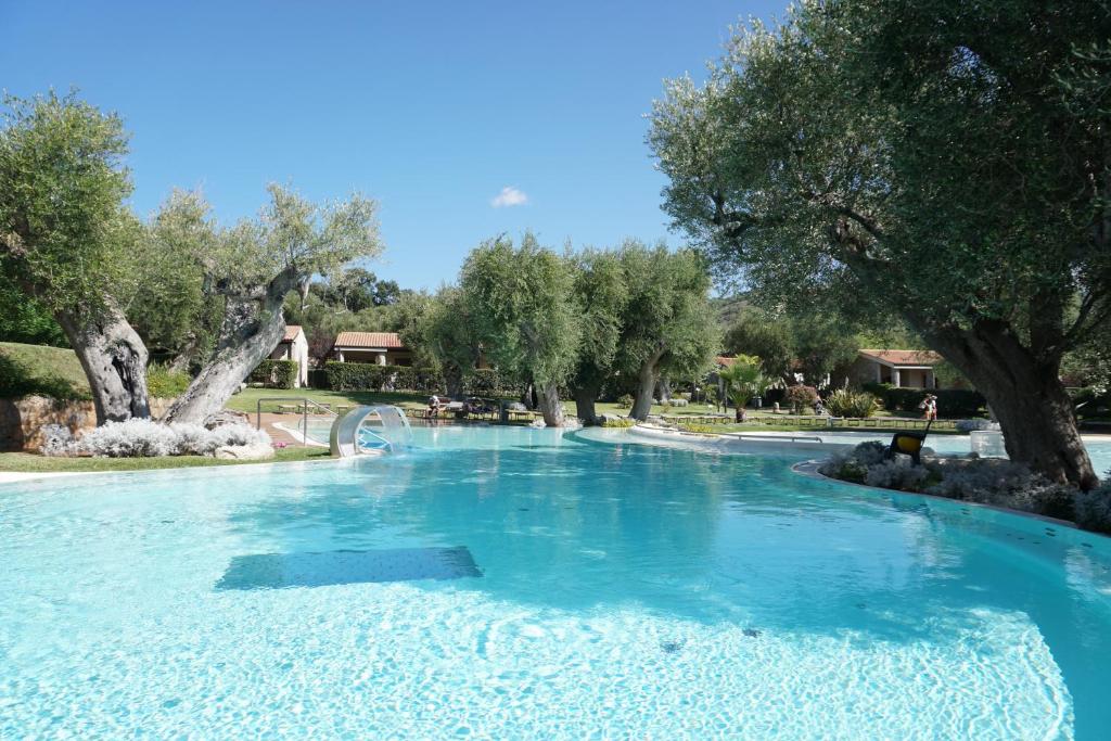una piscina de agua azul en un parque con árboles en Villaggio Blue Marine en Marina di Camerota